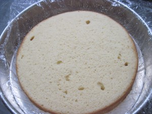 trim top of cake, place it in larger cake pan lined loosely with plastic and carefully spoon on milk mixture