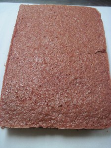 half sheet of red velvet cake cut in half and filled with cream cheese frosting