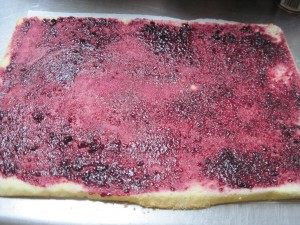 invert the cake onto a piece of paper, soak with syrup and add jam