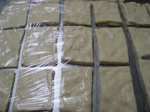 cut squares of beignet resting on the counter while the oil heats up