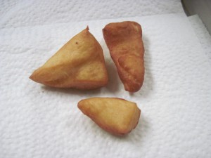 test pieces of beignet checking the temperature of the oil