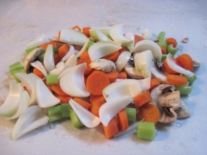 Add cut up veggies to the center of a large sheet of parchment paper