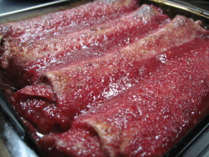 Baked dessert enchiladas filled with chocolate cream and baked in strawberry sauce